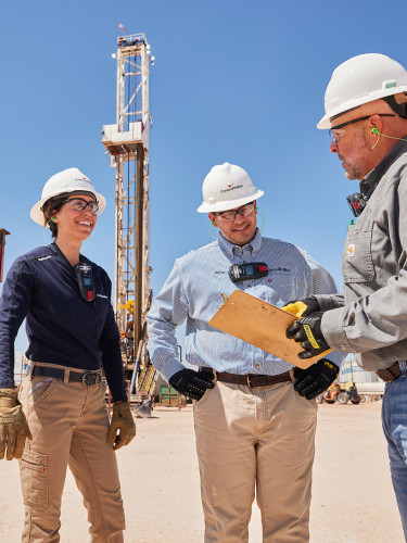 Employees in the Delaware Basin discussing proceedures