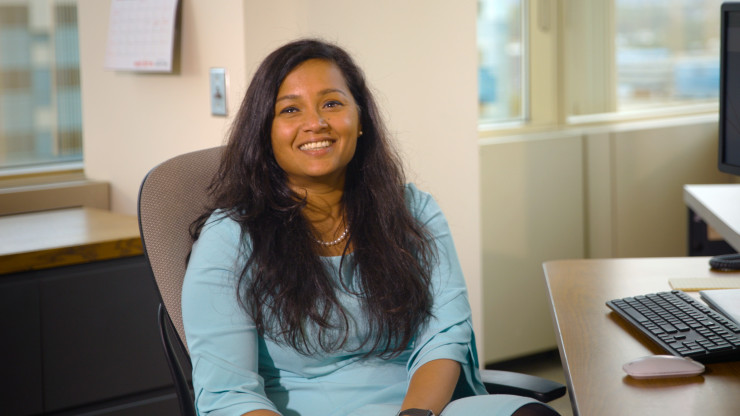 Sanjana sitting in a chair smiling