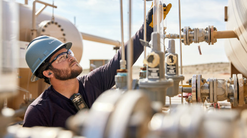 ConocoPhillips multi-skill operator Auston Tennis checks equipment at a central tank battery in the Delaware Basin
