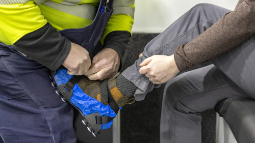 Participants wear special slide shoes while walking on the simulator’s slick surface.