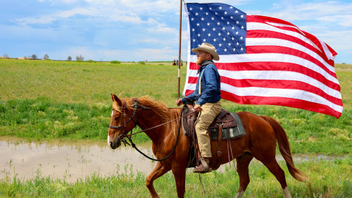 Rough Rider carries the American flag at opening of Teddy Roosevelt Library in North Dakota