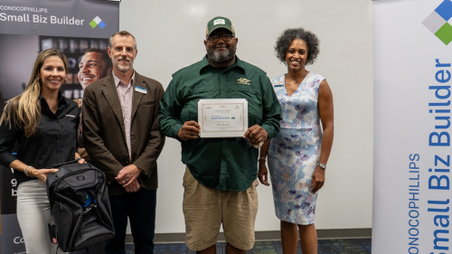 One of the students holding up their graduation certificates.