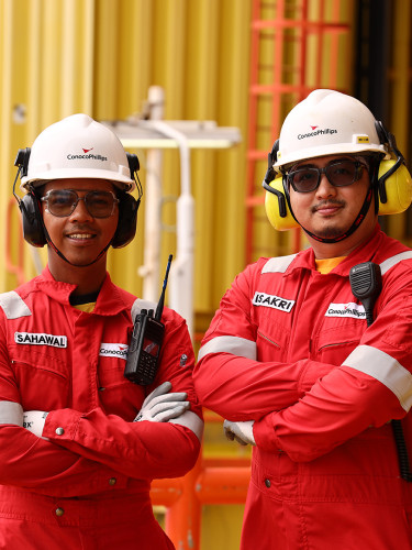 employees in safety outfits and hardhats on a worksite