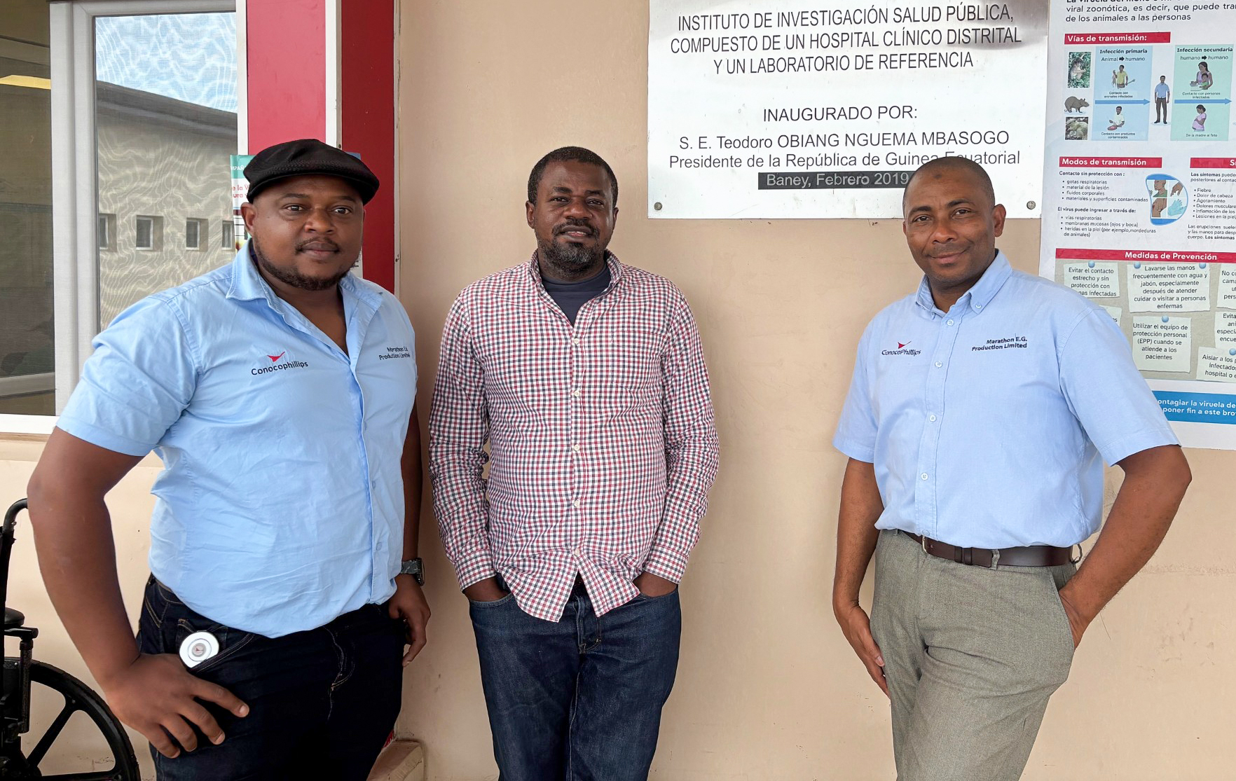 Three men standing outside of building