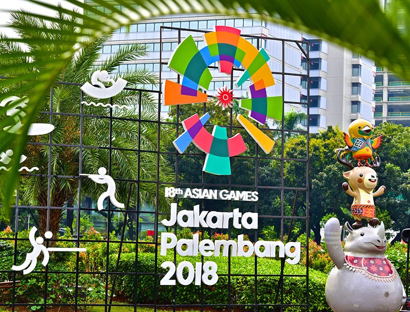 Outdoor sign with people icons and text: 18th Asian Games, Jakarta Palembang 2018