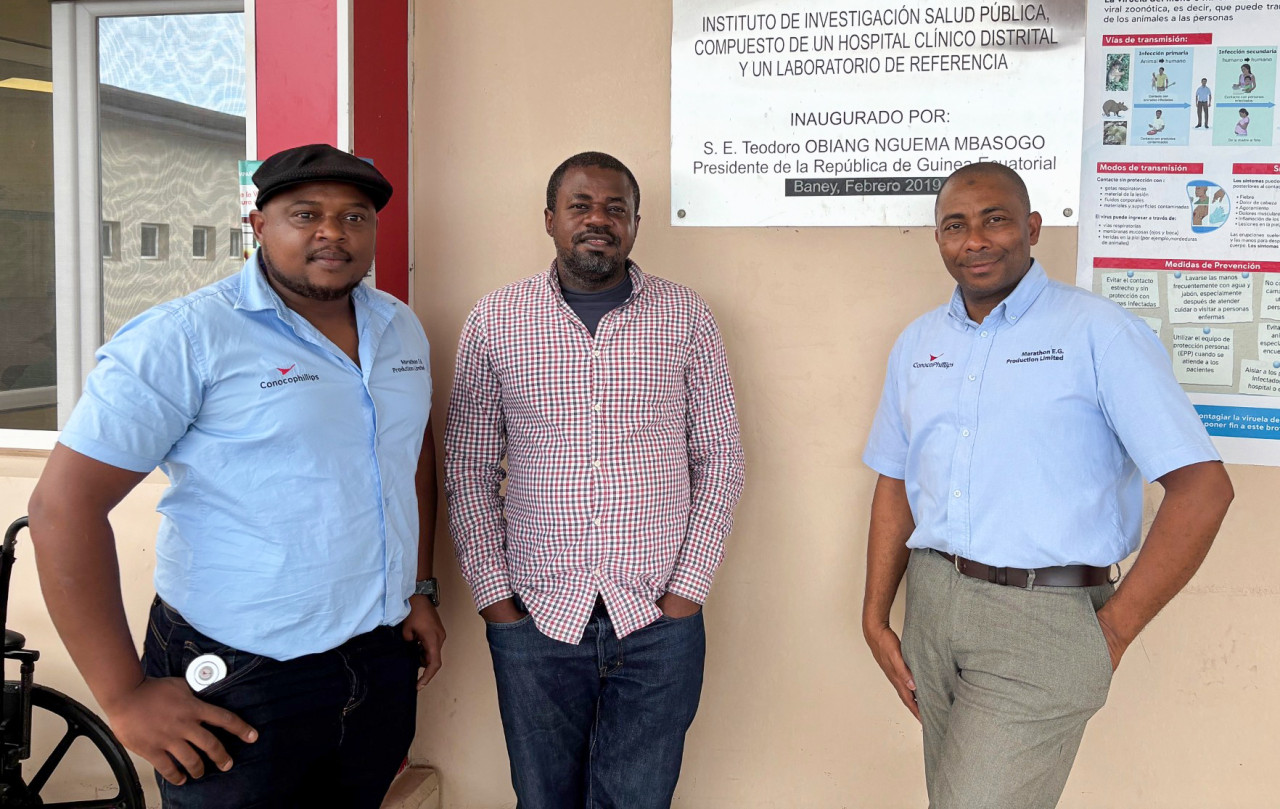 Three men standing outside of building