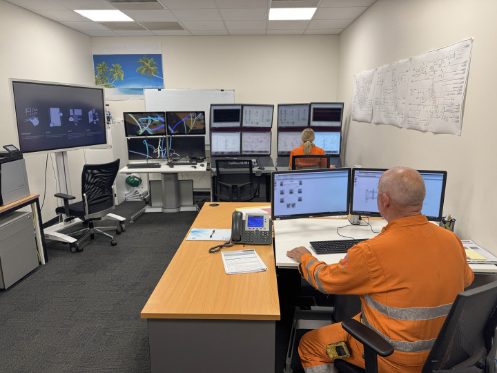 Workers in a simulator training room running a test.