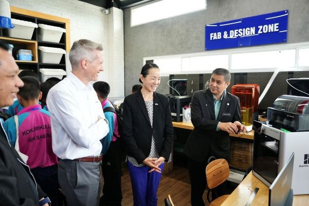 A group learning about the new fabrication machine