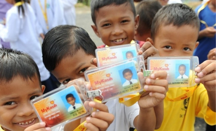 Four young students showing their school ID's
