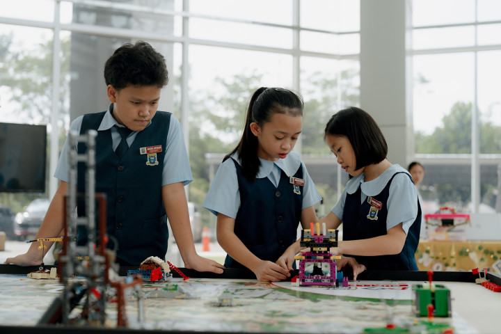 Three students working through a STEM robotic training project