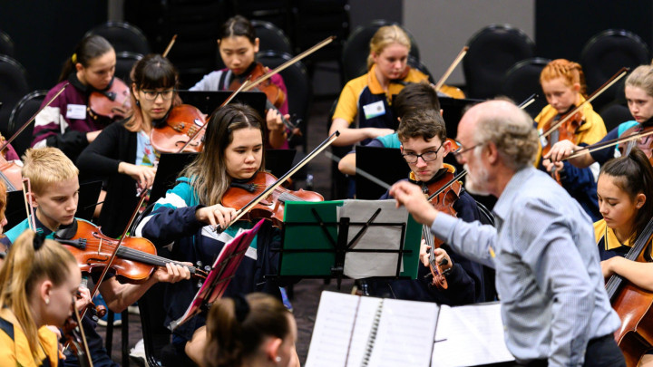 a conductor instructing students in a symphony