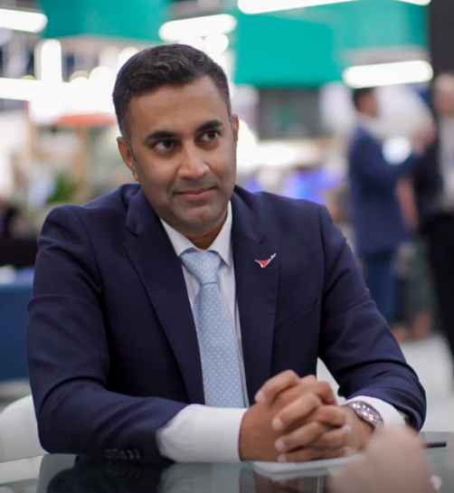 Rajiv Panicker sitting at a table in large indoor space