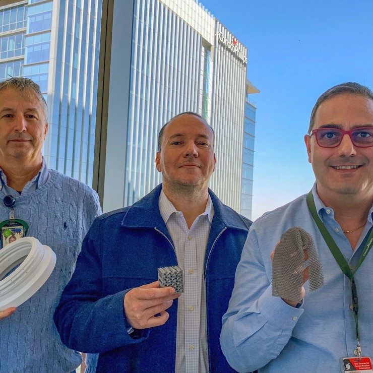 Global Production experts Enzo Savino, Hernan Rincon and Carlo De Bernardi display 3D printed parts. Savino is holding a valve seat made of polyetheretherketone; Rincon is holding a heat exchanger; and De Bernardi is holding a titanium net.
