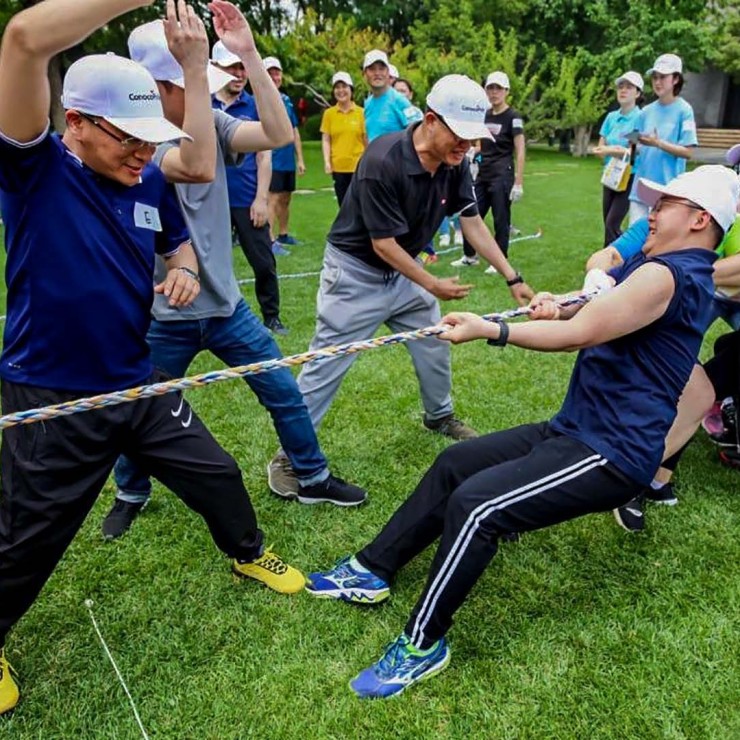 Employees participating in tug of war game