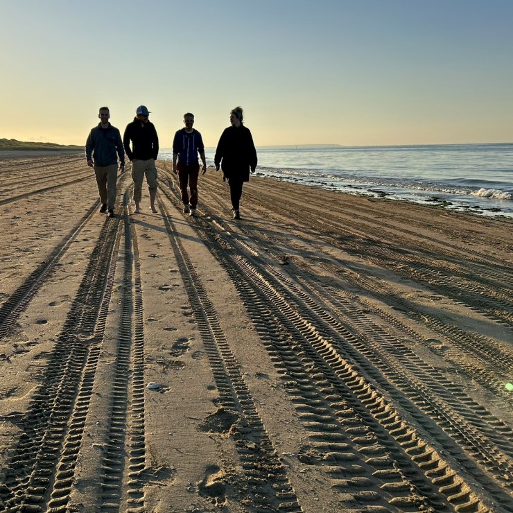 Geologists Dallin Laycock, Glen Burridge, Sam Hudson and Erin Pemberton walking on the beach