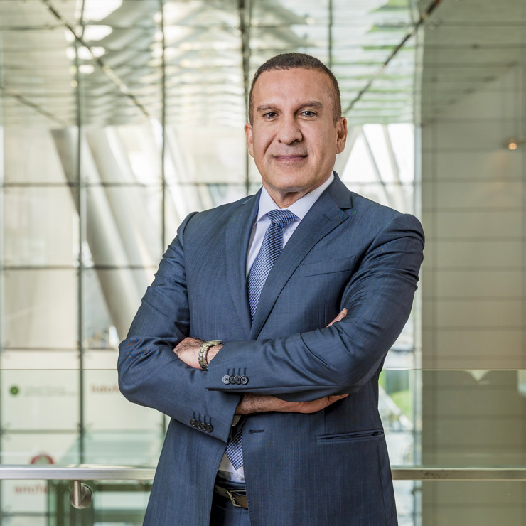 Samer standing in office setting with arms folded